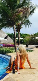 Woman by the pool under palm trees in a tropical setting.