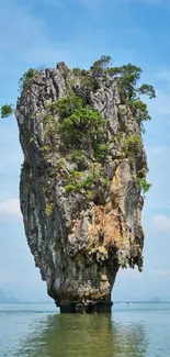 Tropical limestone island rising from turquoise waters with lush greenery.