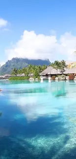 Tropical island with huts, clear blue water, and mountain background.