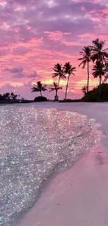 Tropical beach at sunset with pink sky and palm trees.