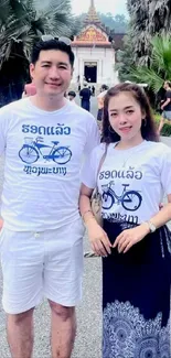 Couple in white outfits at a tropical temple.