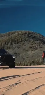 Two trucks parked in a scenic desert landscape with blue skies and mountains.