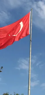 Turkish flag waving against a clear blue sky.