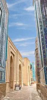 Turquoise mosaic alleyway with intricate designs and blue sky.