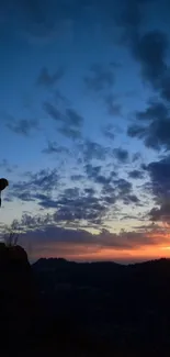 Silhouette against a twilight sky with vibrant sunset hues.