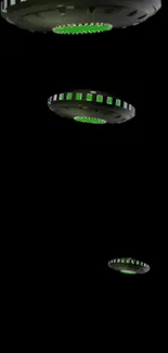 Mobile wallpaper showing UFOs with neon green lights on a black background.