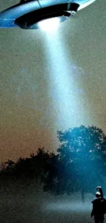 A UFO shines a beam of light on a silhouetted figure in a dark landscape.