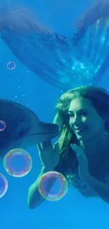 Mermaid and dolphin underwater adventure in deep blue ocean.