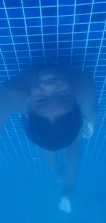 Child swimming underwater in a clear blue pool.