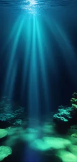 Underwater view with sunlight beams on corals and sea floor.