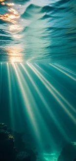 Underwater view with sun rays illuminating teal ocean depths.