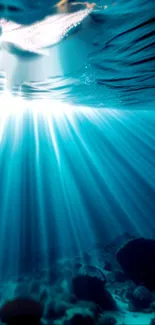 Underwater view with sunlight beams illuminating the ocean floor.