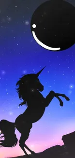 Silhouette of a unicorn against a starry night sky with a large moon.