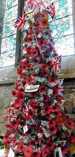 Christmas tree with poppies and Union Jacks against a stone wall.