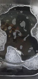 Aesthetic shot of a kitchen sink with soapy water and foam.