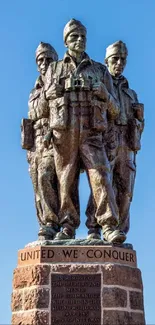 Bronze statue of soldiers against a blue sky.