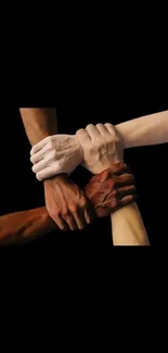 Diverse hands joined together against a black background, symbolizing unity and strength.