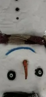 Upside down snowman with scarf in snow.