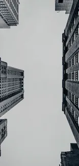 Monochrome view of skyscrapers from below against gray sky.