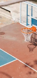 Terracotta basketball court with hoop and shadows.