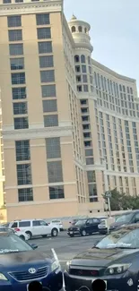 Stylish cars in front of high-rise building against a clear sky.