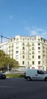 Urban cityscape with classic building and street traffic set against a blue sky.