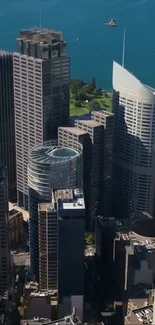 Aerial view of tall skyscrapers by the waterfront under a clear blue sky.