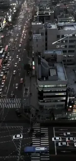 Aerial night view of a bustling city street with glowing headlights.