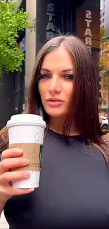 Woman holding coffee in urban setting