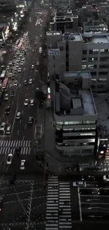 Aerial view of city streets at dusk with vibrant traffic and buildings.