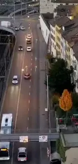 Aerial view of a city street at dusk with cars and buildings.