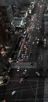 Aerial view of evening city traffic with glowing lights and bustling streets.