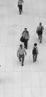 Black and white urban scene with pedestrians on a tiled surface.