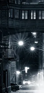 Monochrome alleyway at night with streetlights.