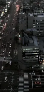 Night cityscape with urban lights and traffic from above.