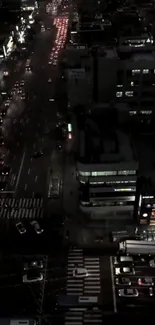 Aerial view of a city street illuminated at night with vibrant lights and traffic.