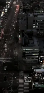 Aerial view of a city street at night with busy traffic and bright lights.