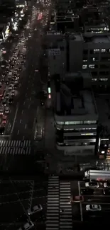 Aerial view of a bustling city street at night, filled with vibrant lights and traffic.