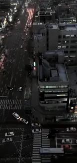 Aerial view of a city street at night with moving traffic and bright lights.