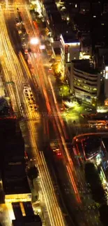 Aerial view of city at night with vibrant light trails.