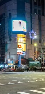 A vibrant urban street scene at night with bright city lights.