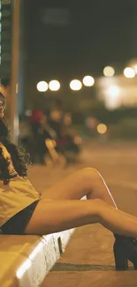 Young woman sitting on city street curb at night.