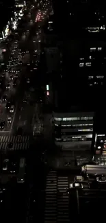 A city street view at night with busy traffic and illuminated buildings.