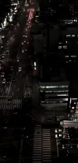 Nighttime urban street with traffic and lights.