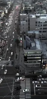 Aerial view of a busy urban street at night with car lights and tall buildings.