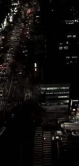 Aerial view of a city street at night with glowing streetlights and traffic.