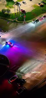 Aerial view of urban intersection with vibrant night lights and moving traffic.