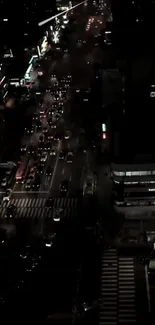 Top view of urban night traffic with city lights and skyscrapers.