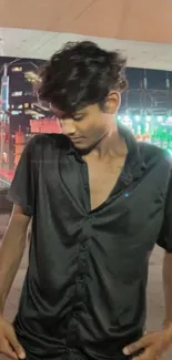 Stylish individual in black shirt enjoying the vibrant urban nightlife.