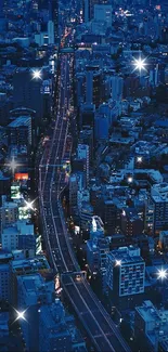 Aerial view of city at night with glowing streets and blue tones.